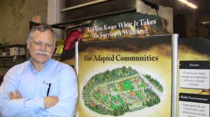 A picture of Ed Smith standing in front of a Fire Adapted Communities display.