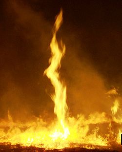 Imagen de un remolino de fuego, o imagen de llamas de fuego con una llama larga que gira hacia arriba.             